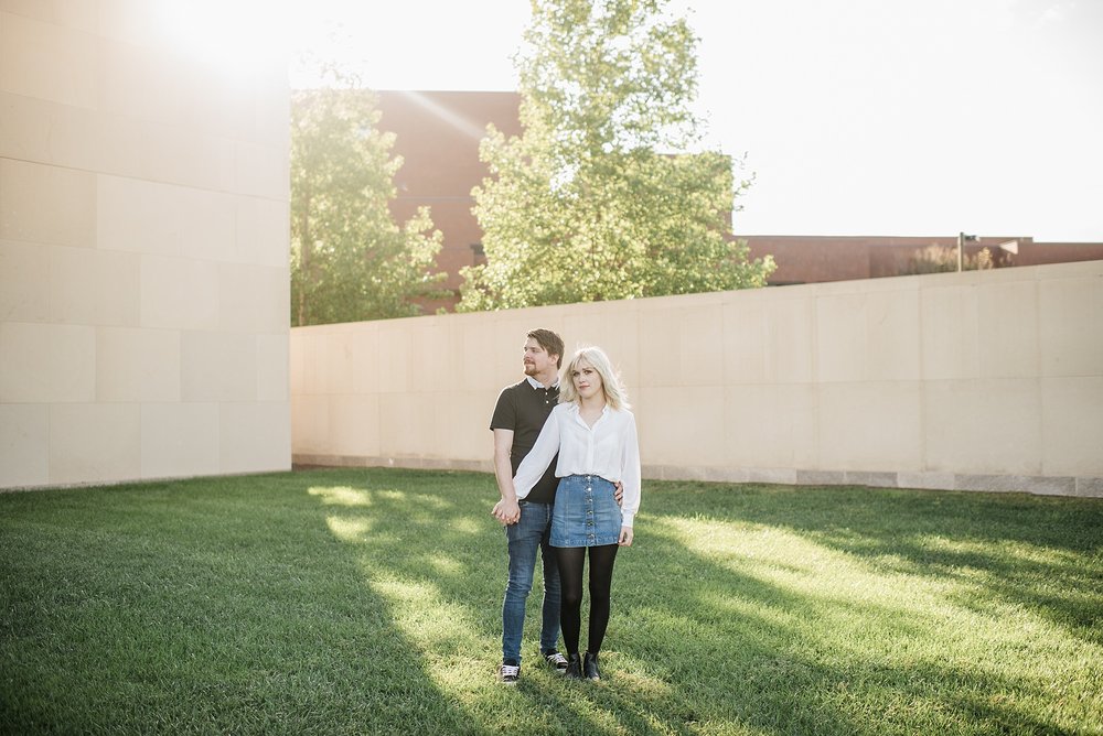 Couple cuddling at Nerman Museum with sunflare