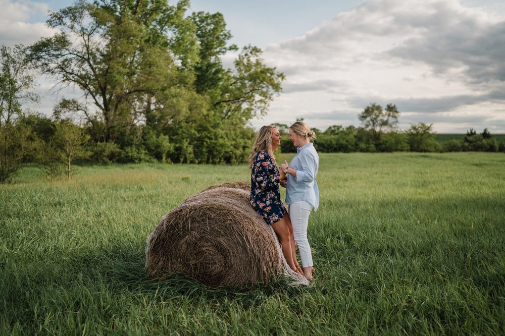 Two women kissing on a hay bale in Clinton Lake
