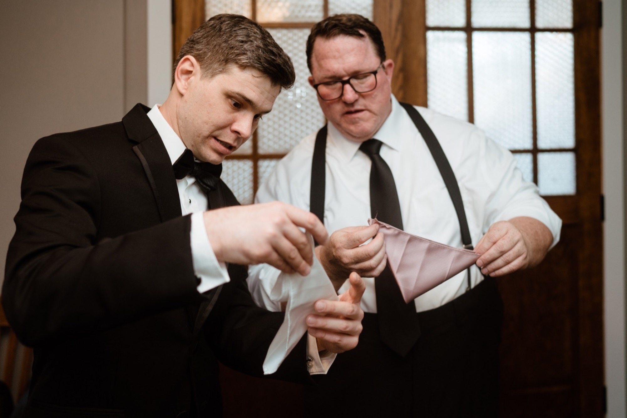 father and son fold handkerchiefs at 8th and main wedding