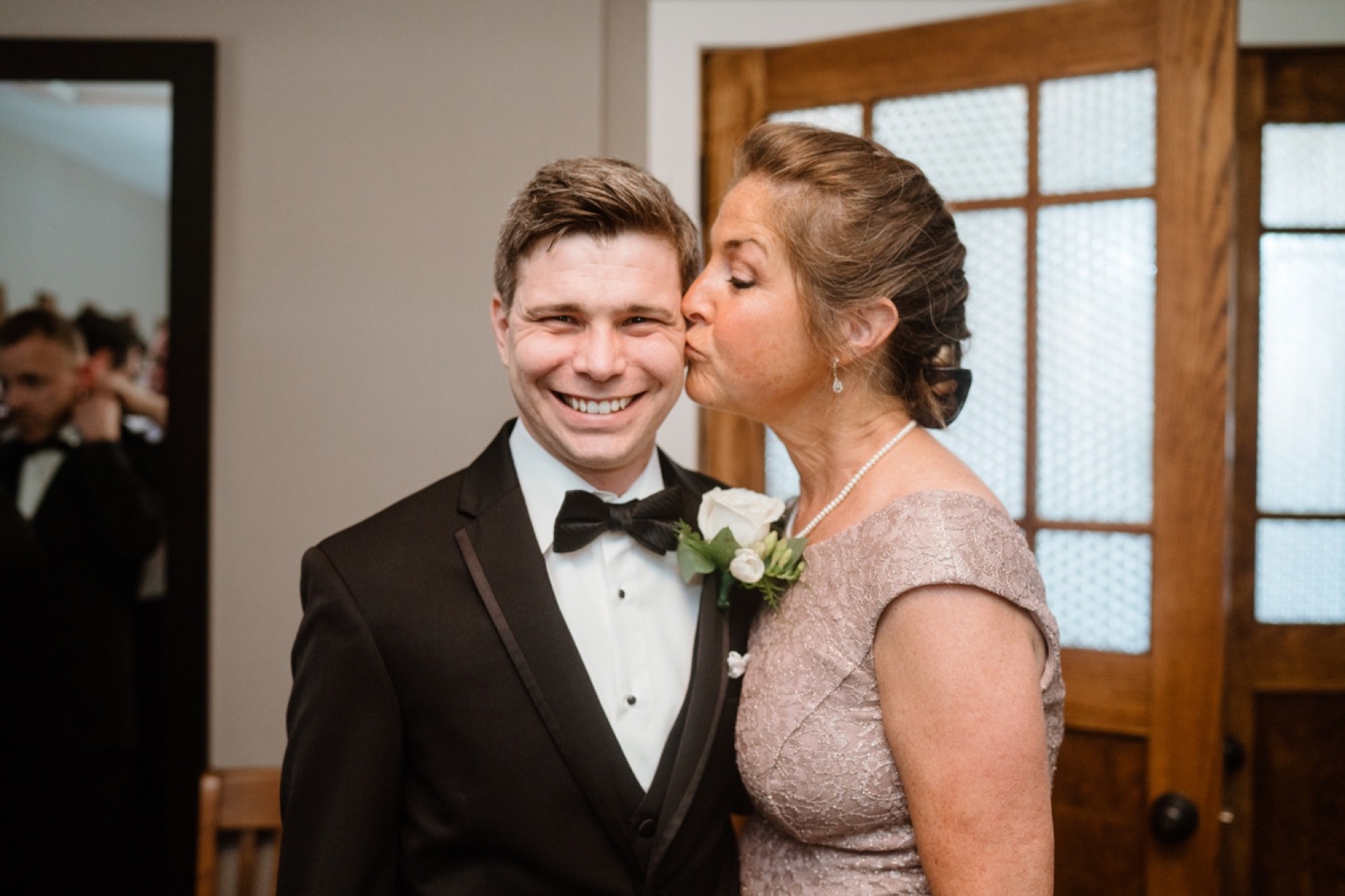 mother of groom kissing groom during 8th and main wedding