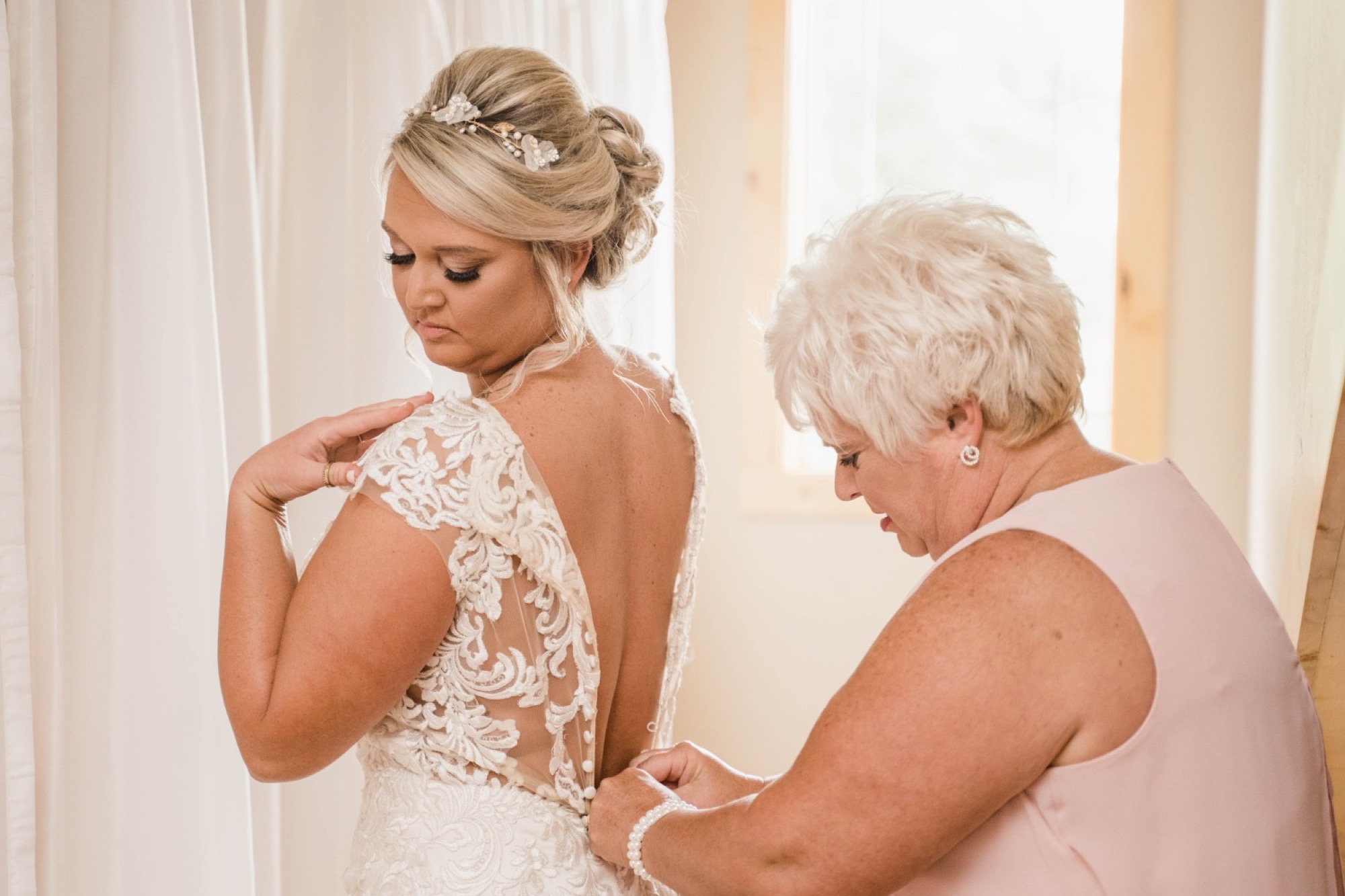 chateau at white oak - bride putting on dress with her mom