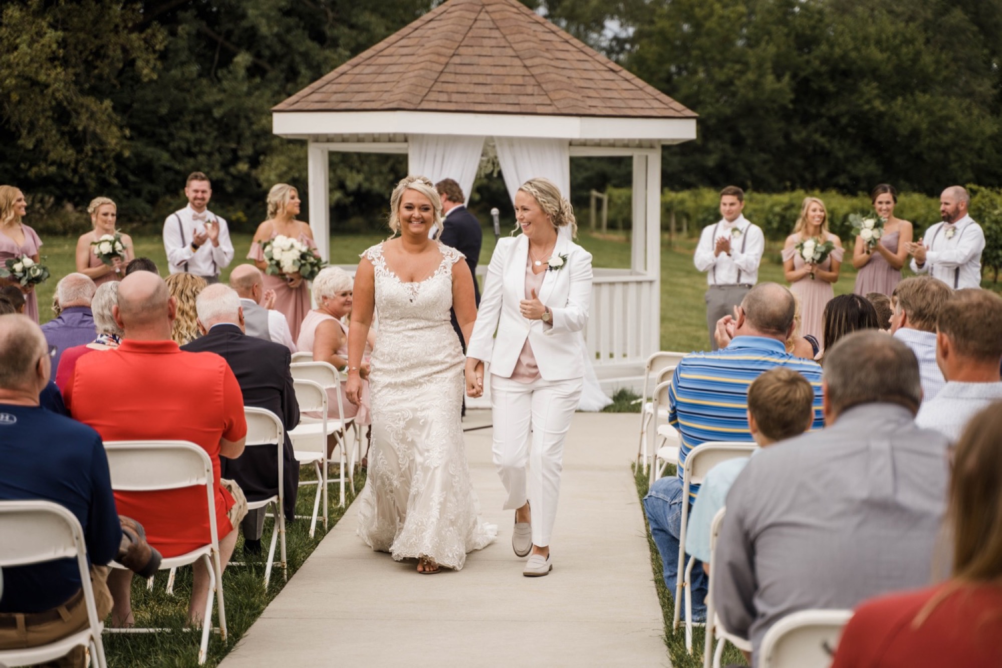 chateau at white oak bride gives thumbs up to family during recessional