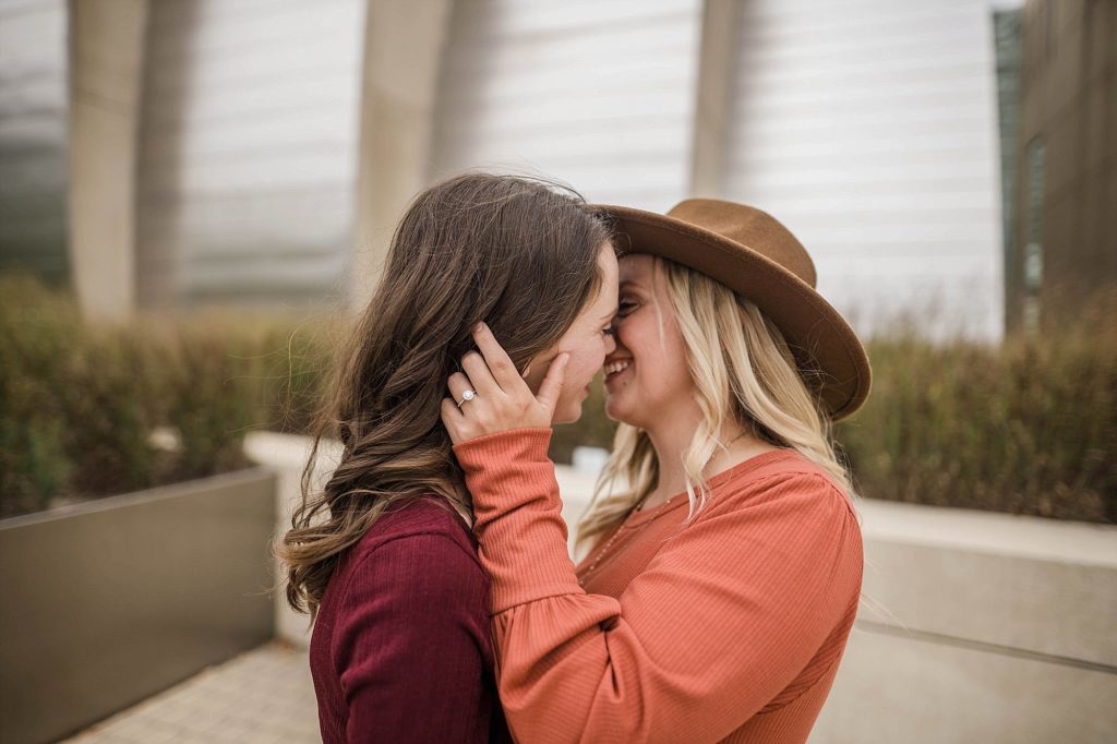 couple comes in close for a kiss during kauffman center engagement