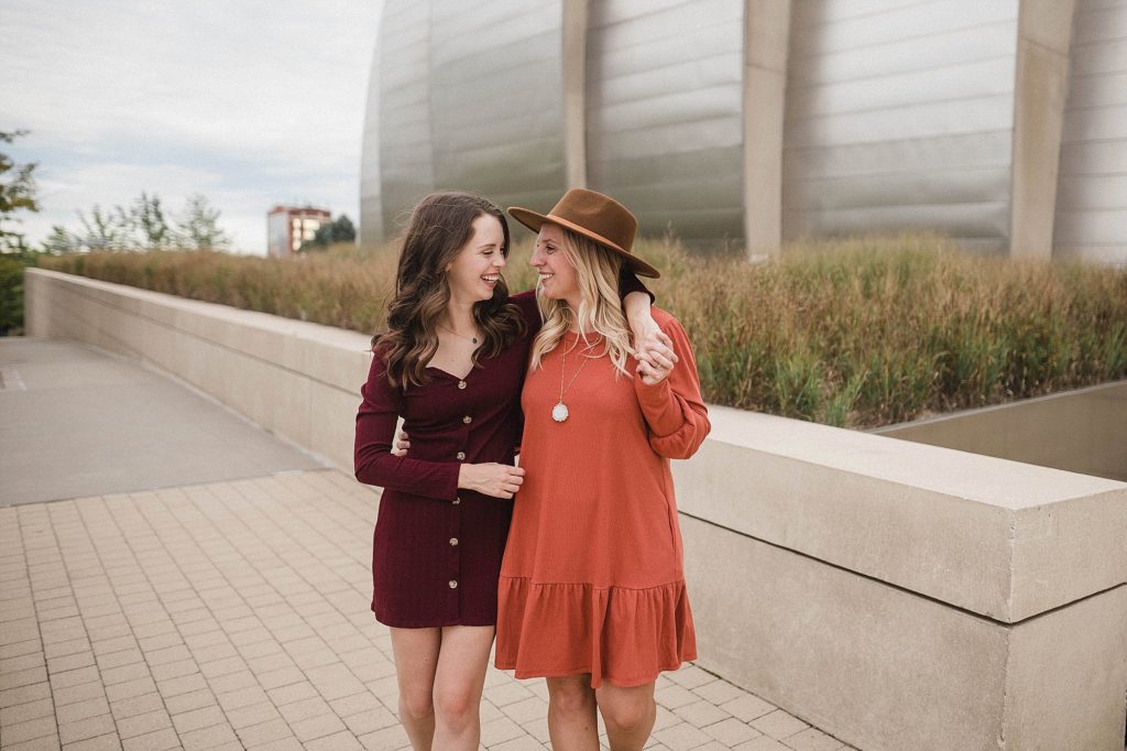 couples walk arm in arm at kauffman center engagement