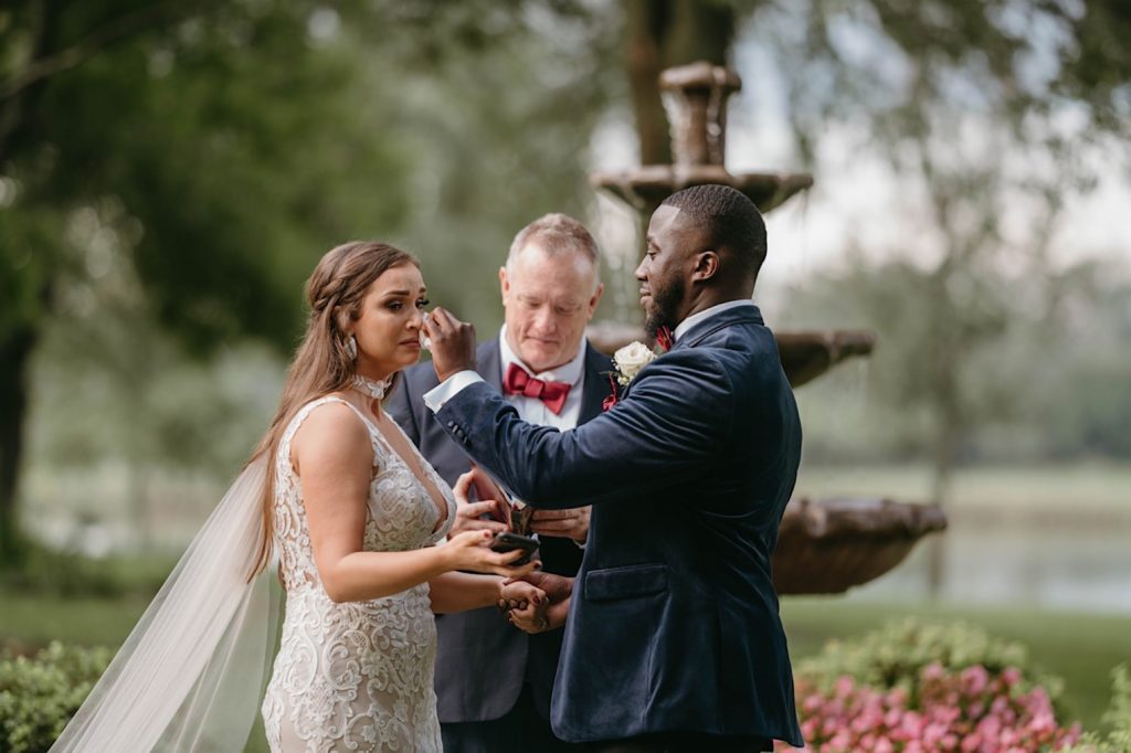 Groom wipes tear from bride's eye during intimate KC backyard wedding