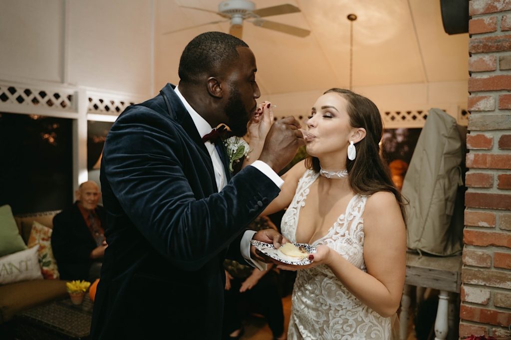 bride and groom share cake during their intimate backyard elopement