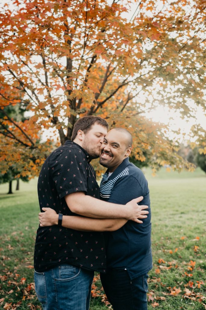 couple kisses cheeks at loose park engagement