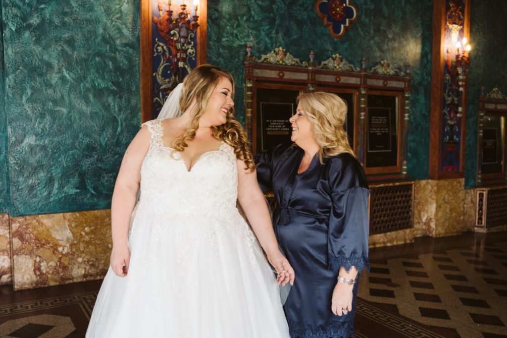 mom helps bride get dressed during uptown theater wedding