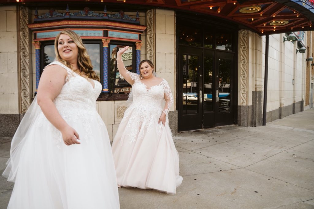 brides wave at passerbys at uptown theater wedding