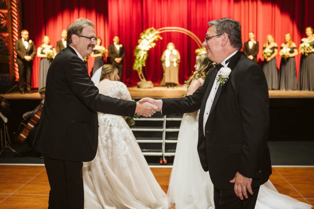 brides father's shaking hands on stage at uptown theater wedding
