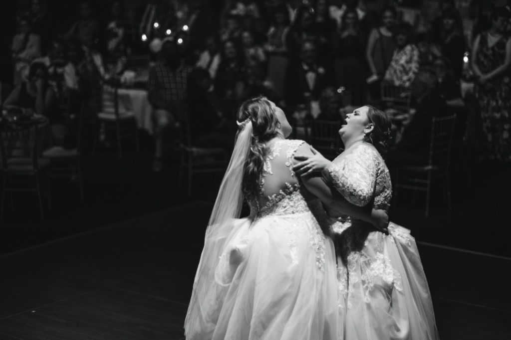 brides sing to each other at uptown theater wedding