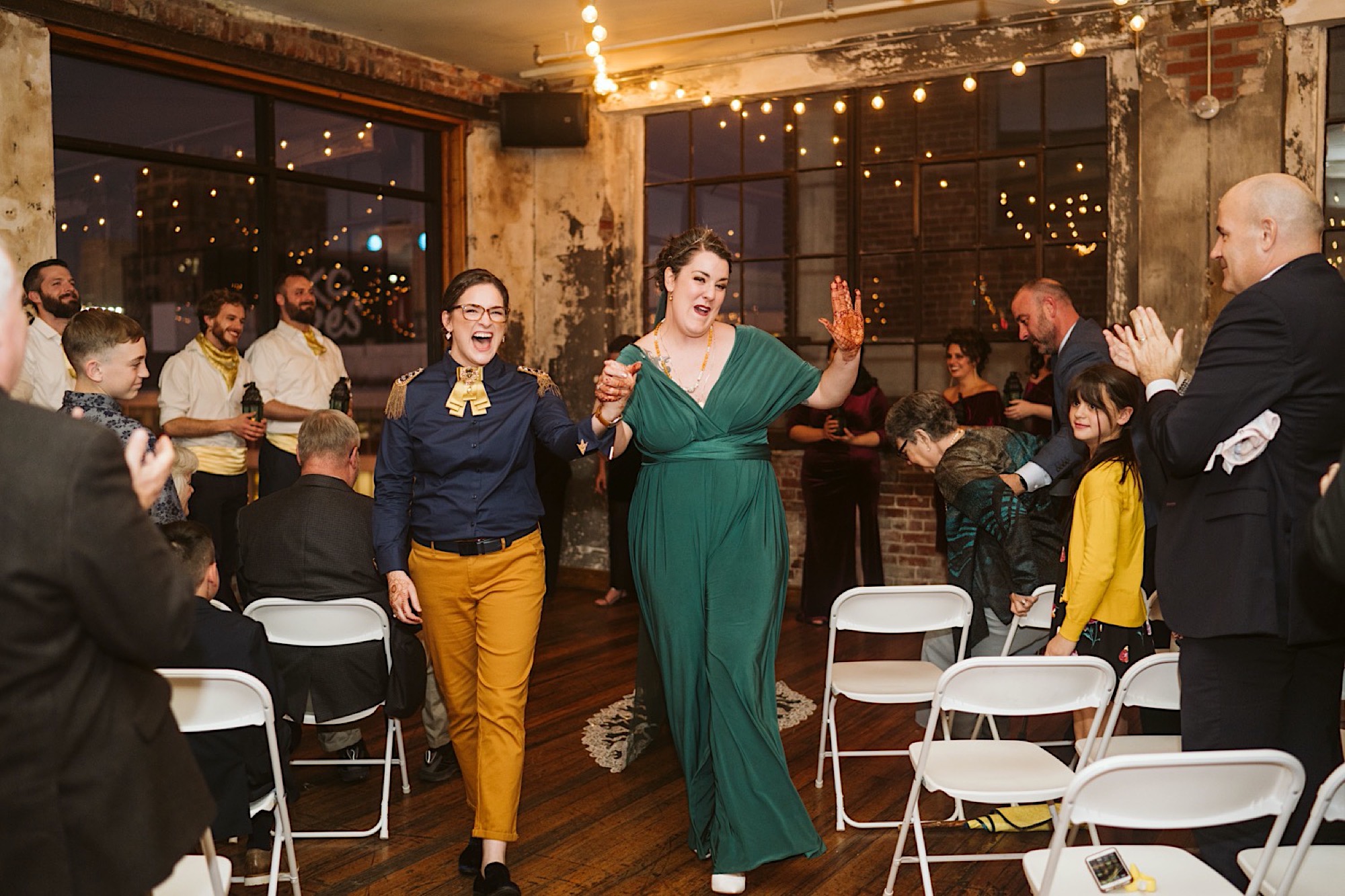 couple walks down aisle as wife and wife at bride and bauer sustainable wedding