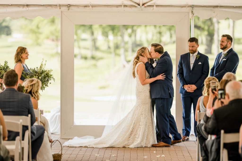couple shares first kiss during wedding ceremony at kc national golf club