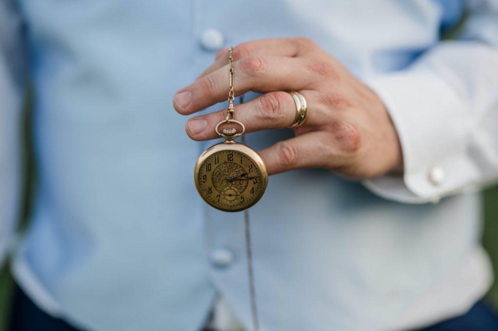 groom shows off his monogrammed pocket watch 