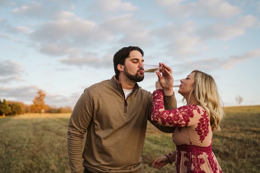 couple drinks prosecco during their shawnee mission park engagement session