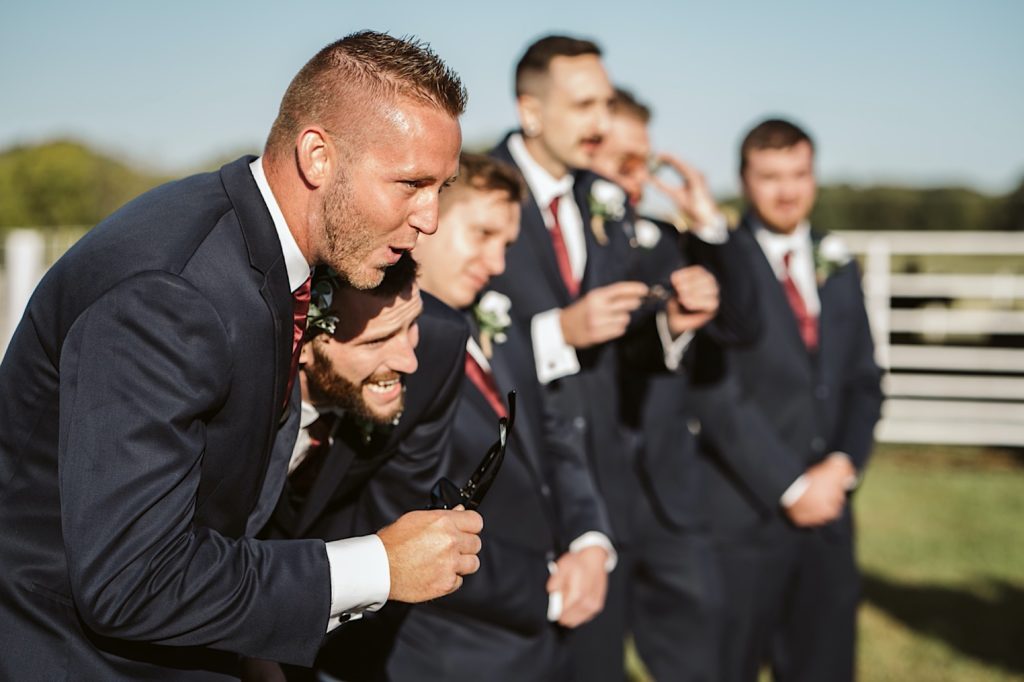 groomsmen take off their glasses to see bride during sweet clover farms wedding