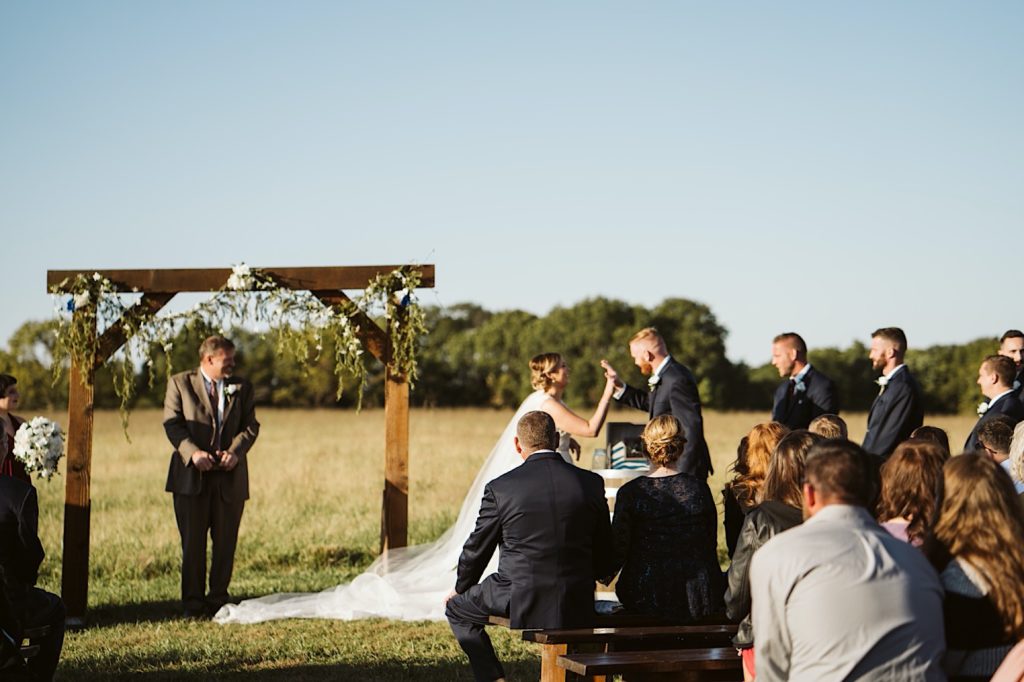 couple high fives during sweet clover farm weddings sand ceremony