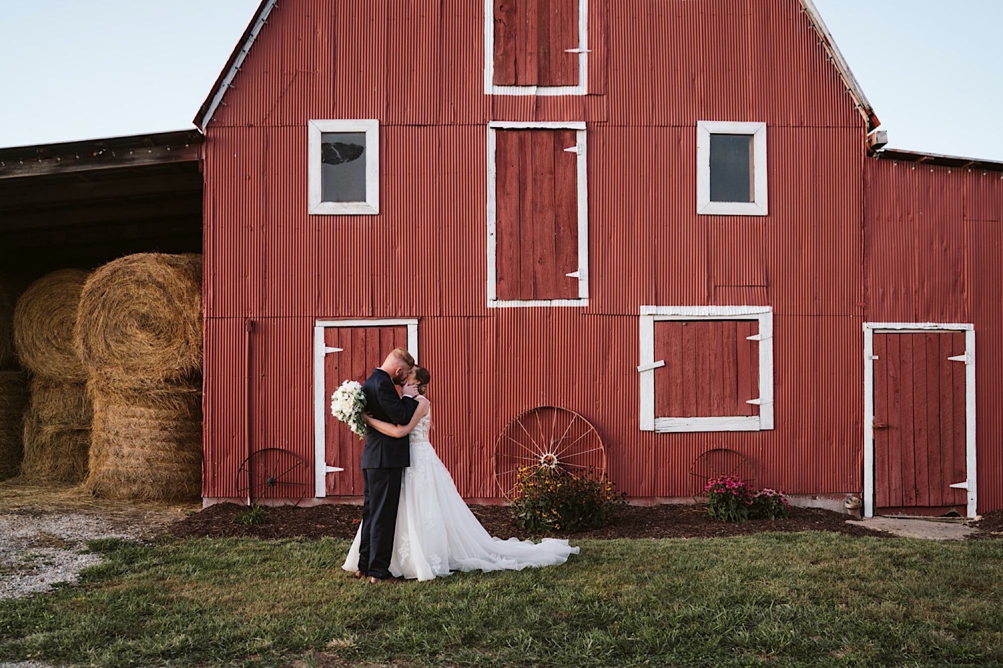 couple poses in front of sweet clovers farm wedding barn