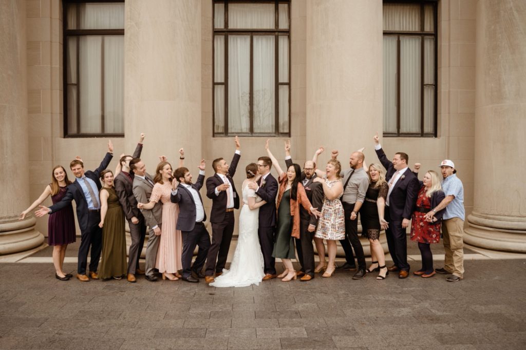friends cheer at grand street cafe wedding during portraits