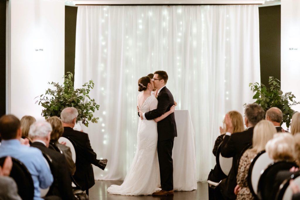 Couple shares their first kiss at grand street cafe wedding