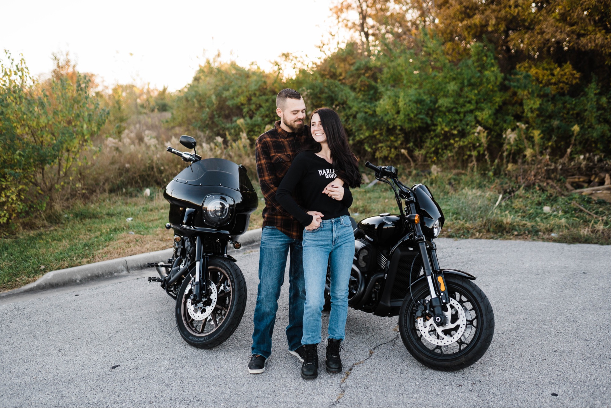 Couple cuddles by their motorcycles for their hodge park engagement session