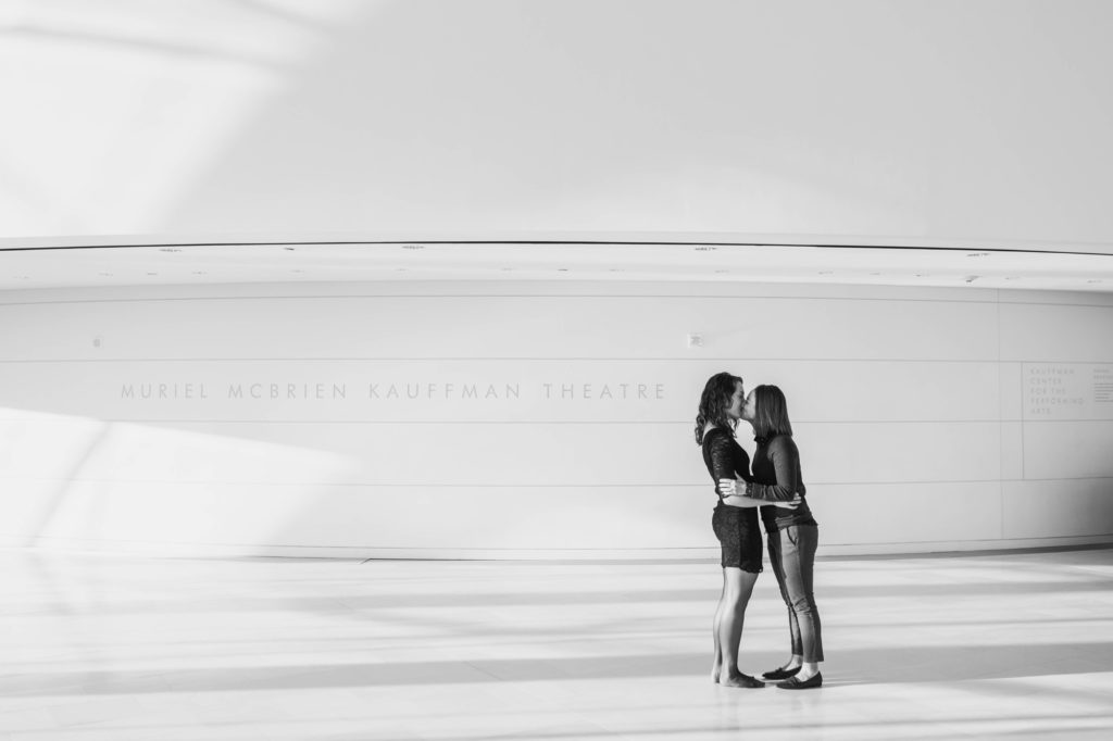 same sex couple kisses in lobby during kauffman center engagement