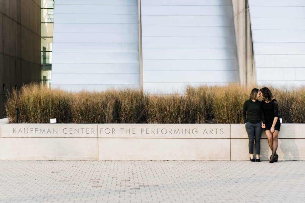 couple sits on placard at Kauffman Center Engagement Session