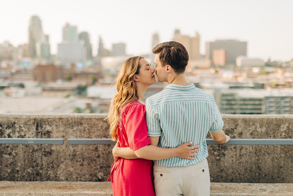 Couple kisses with city view in the background of this sheraton parking engagement session