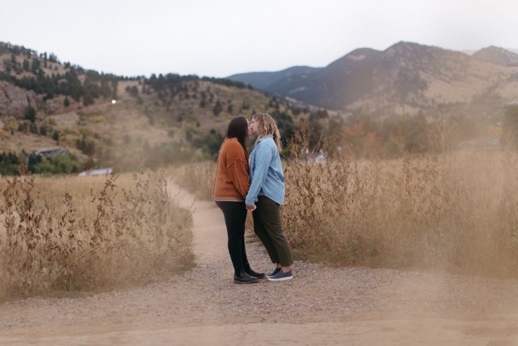 Two women kiss at Chautauqua Park Engagement Session
