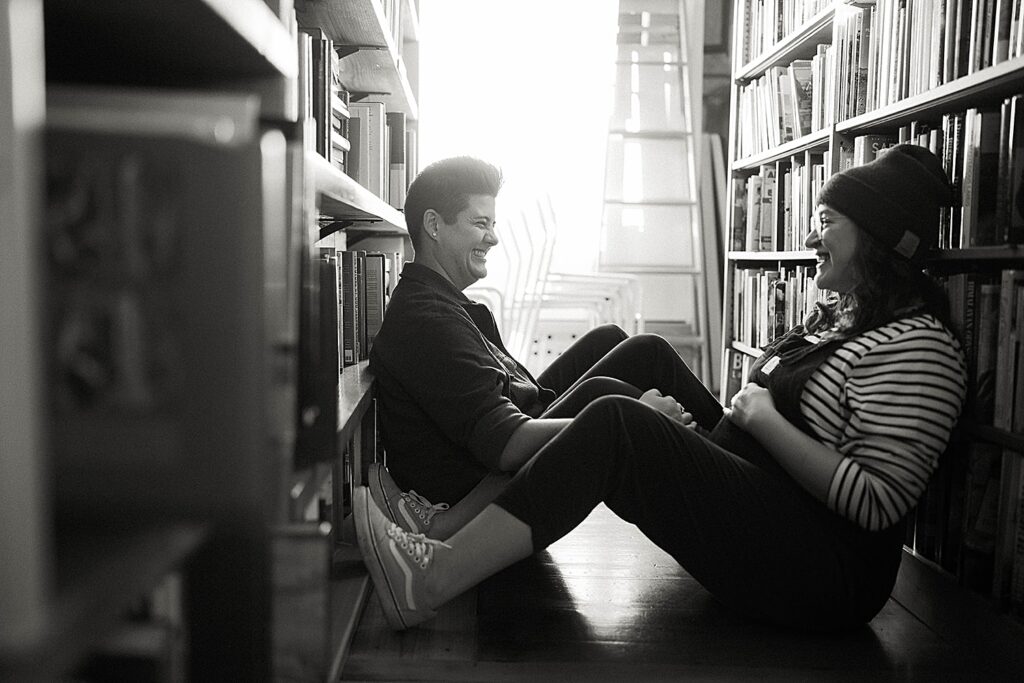 pregnant woman leans against bookstore stacks in kansas city