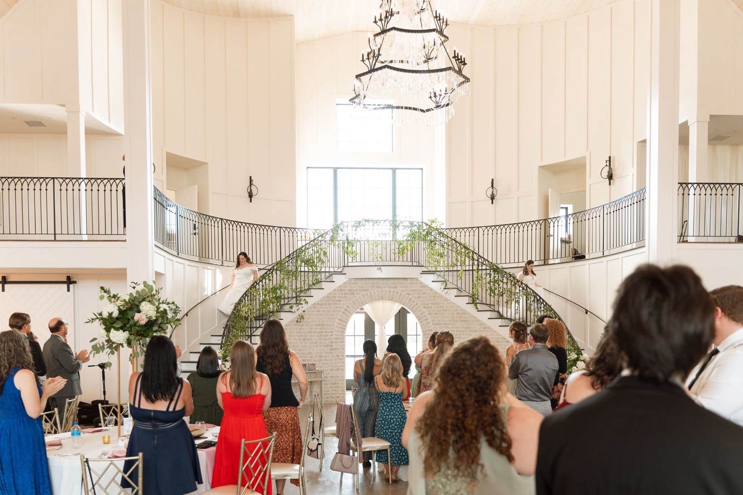 Two brides walk down grand staircase for White Iron Ridge LGBTQ+ Wedding