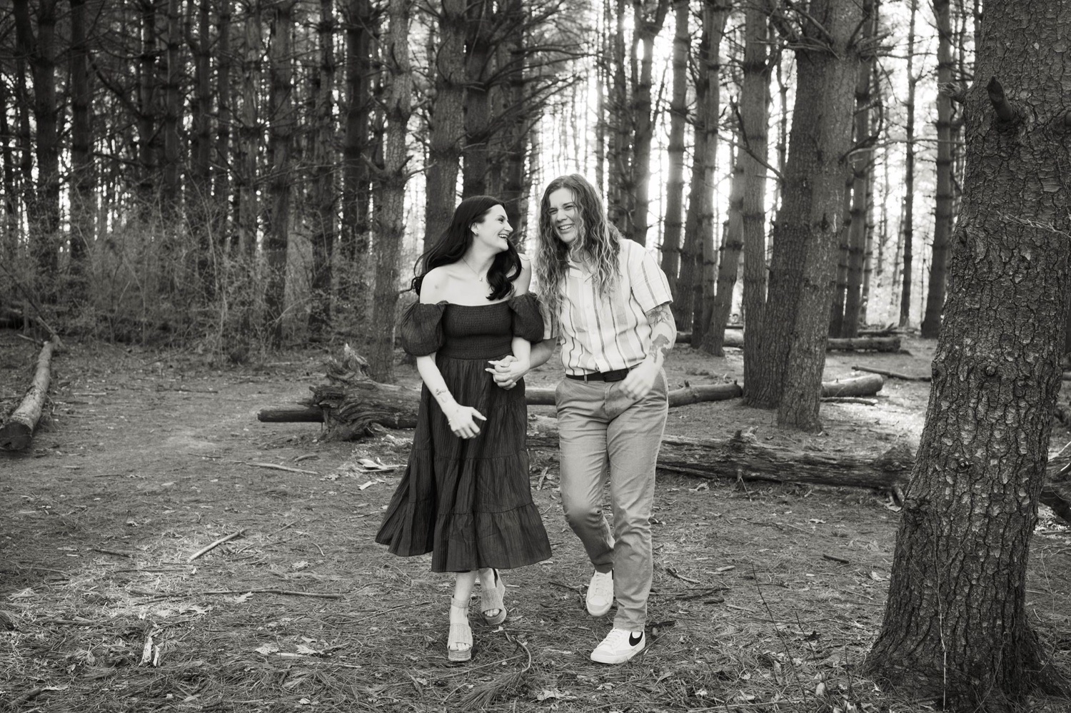 Couple laughs while walking together during surprise proposal session at Burr Oaks Woods